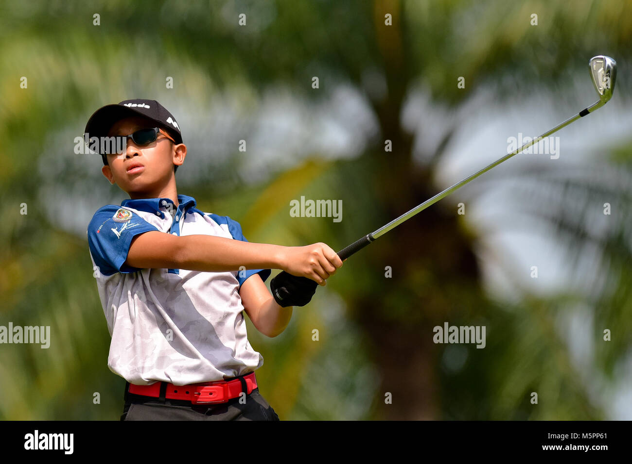 Danau, UKM Bangi - FEBRUARY 11: Irvyn Tan Sheng Kang watches his tee shots on the 6th hole during Final Round of the Danau Junior Championship at Dana Stock Photo