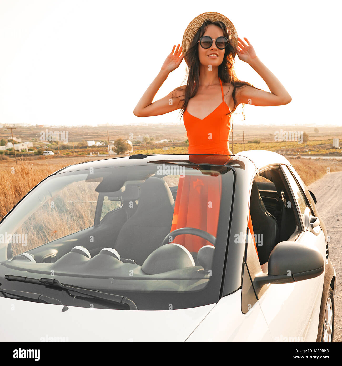 Outdoor lifestyle photo of beautiful happy woman in car cabriolet. Holiday and travel. Summer trip. Freedom, youth and carefree Stock Photo