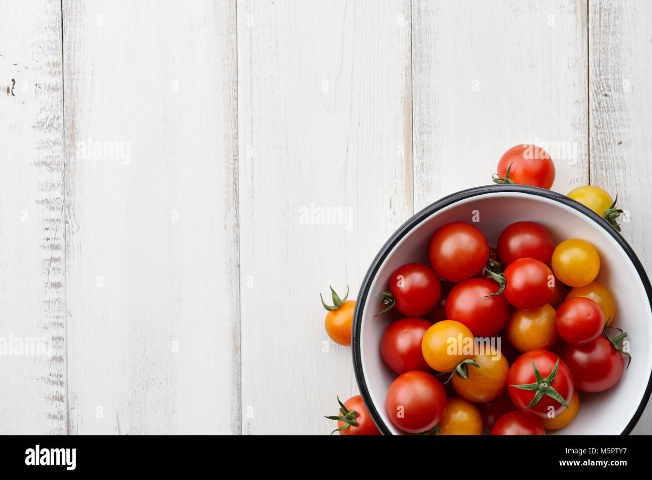 Bright red and yellow tomatoes on white wooden table, top view Stock ...
