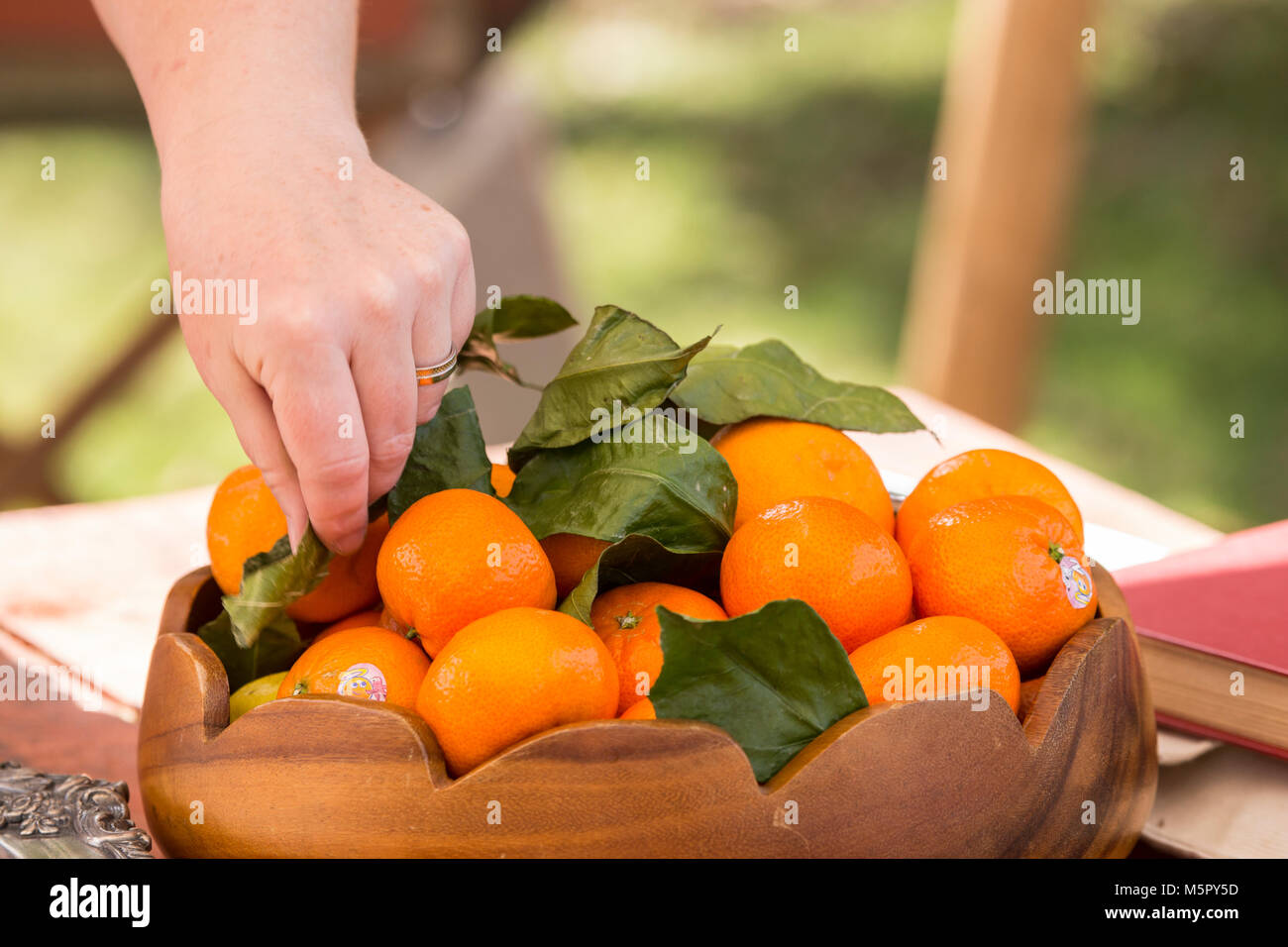 Wooden bowl of tangerines on a outside table Stock Photo
