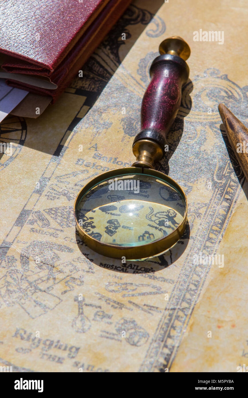 A brass magnifying glass with a wood handle on a old fashion map Stock ...