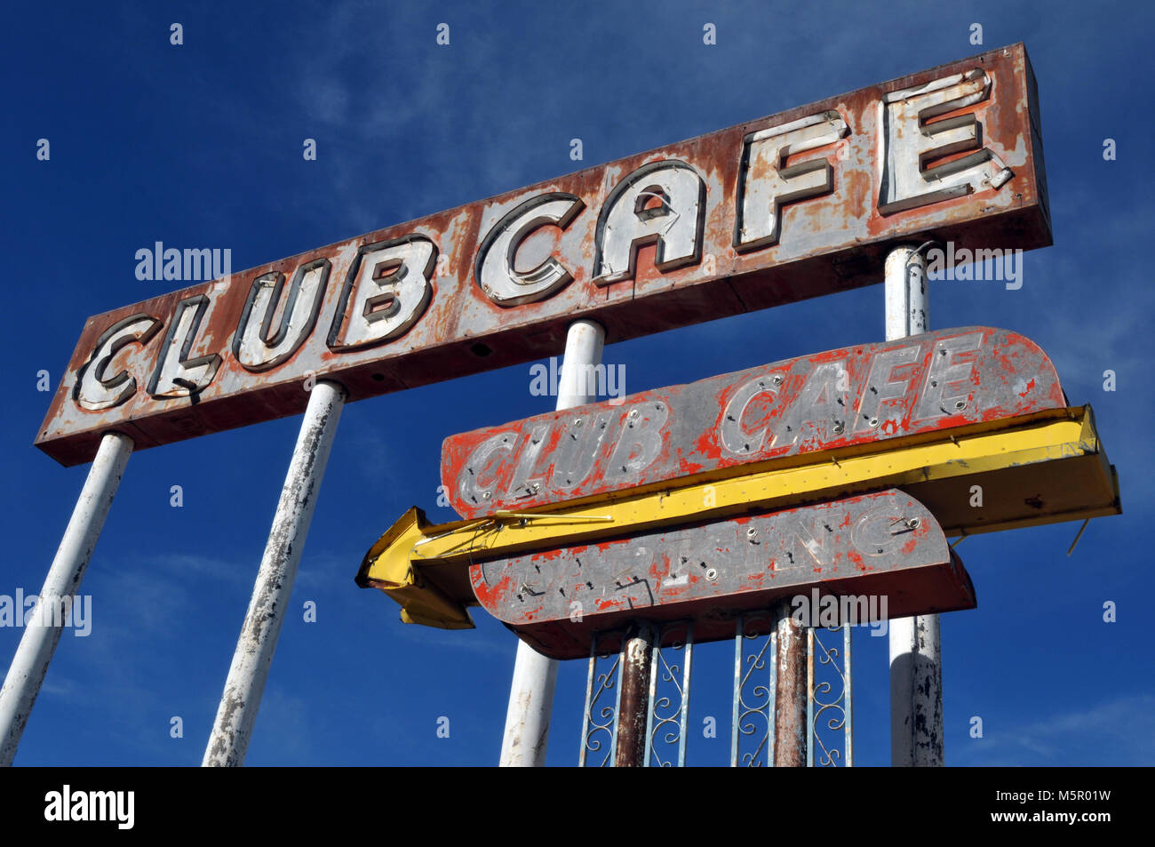 Faded sign for the former Club Cafe restaurant in the Route 66 town of Santa Rosa, New Mexico stands against a bright blue sky. Stock Photo