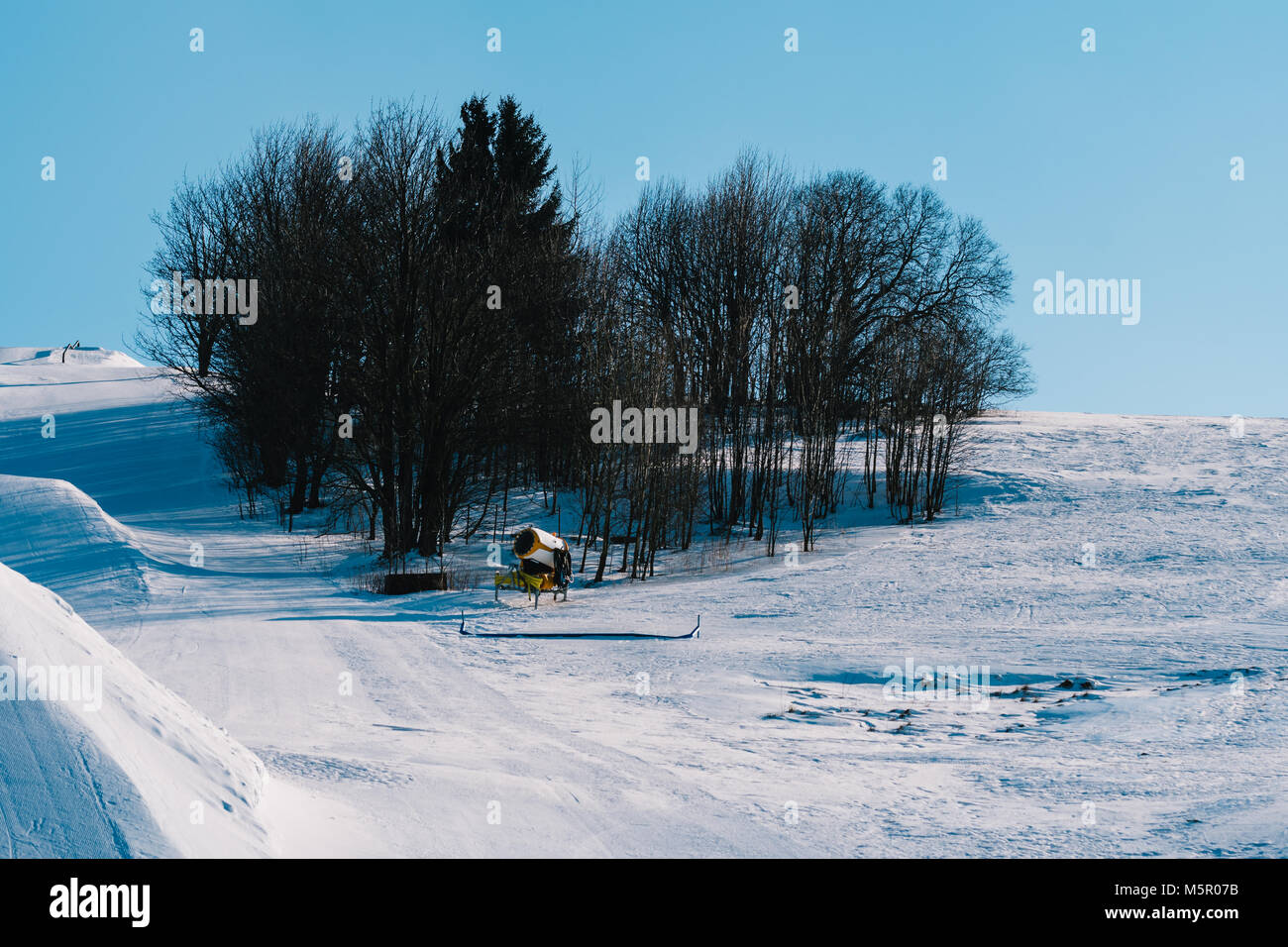 Snow gun machine waiting for frost with sun flare background, snowmaker  machine. Color effect Stock Photo - Alamy