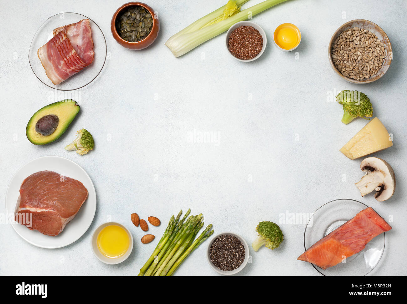 Ingredients for ketogenic diet: meat, bacon, fish, broccoli, asparagus, avocado, mushrooms, cheese, sunflower seeds, chia seeds, pumpkin seeds, flax s Stock Photo