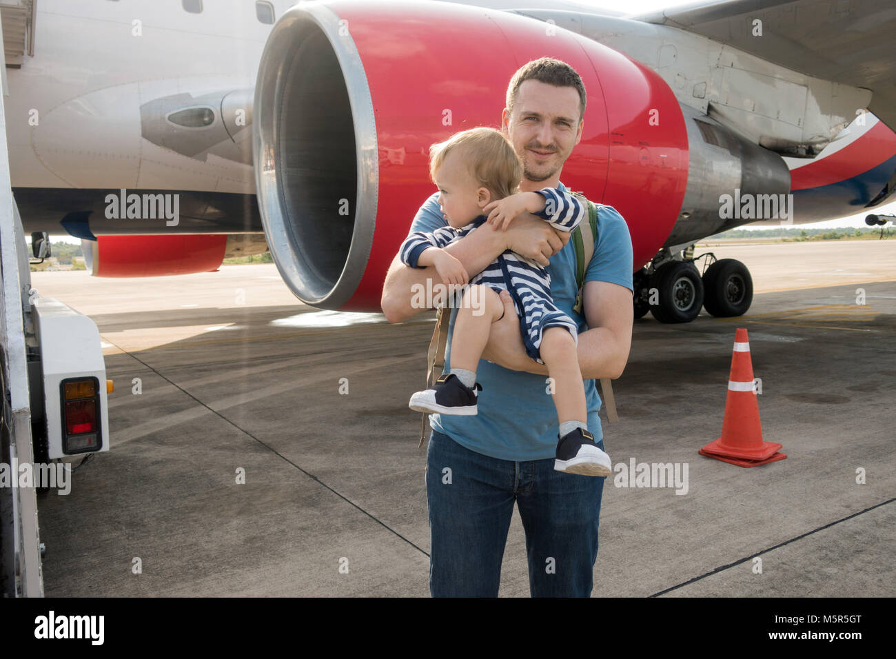 Father and child boarding on plane in airport Stock Photo
