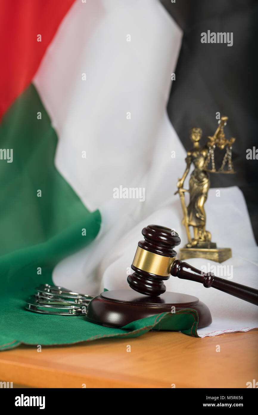 Judge's gavel on a flag of the United Arab Emirates. Statue of Themis