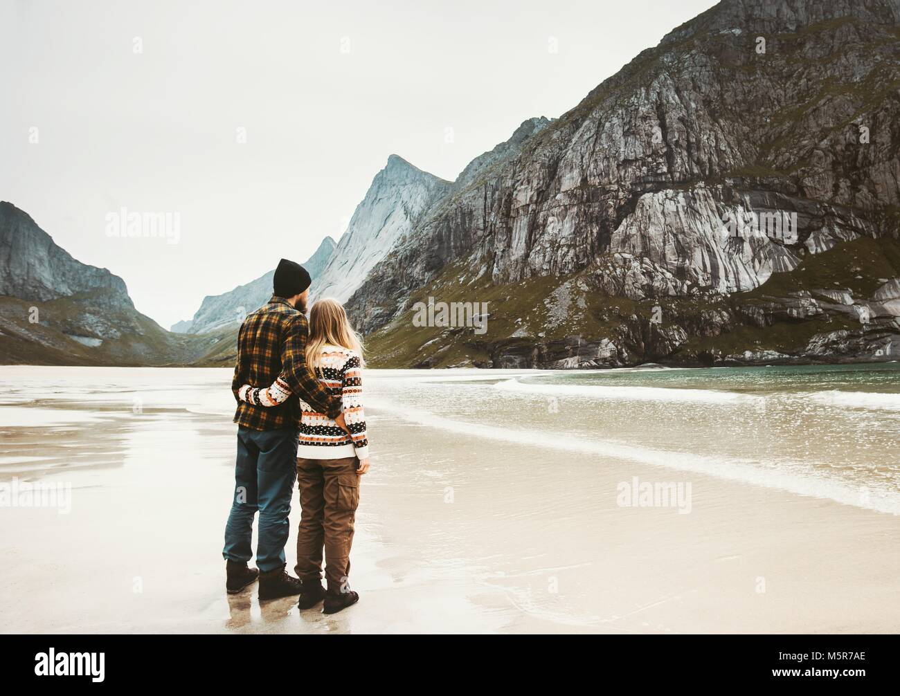 Couple in love hugging on sea beach in Norway traveling lifestyle family man and woman concept romantic vacations together Stock Photo