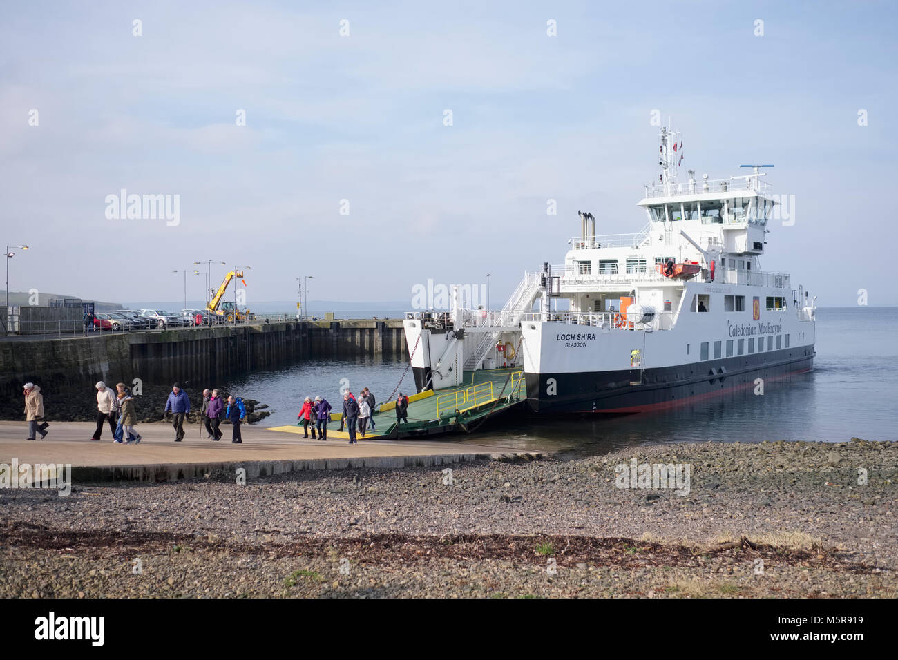 Ferry arrival at port dock with people passengers walking off board to island Stock Photo