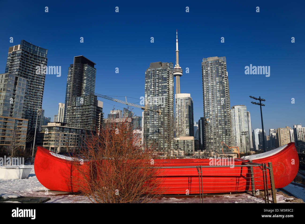 Red canoe in Canoe Landing Park in downtown Toronto with highrise condos and CN tower Stock Photo