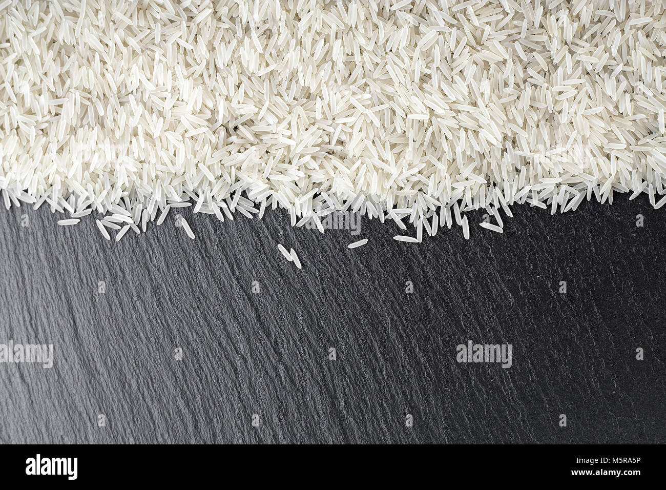 raw rice scattered on the slate, space for text Stock Photo - Alamy