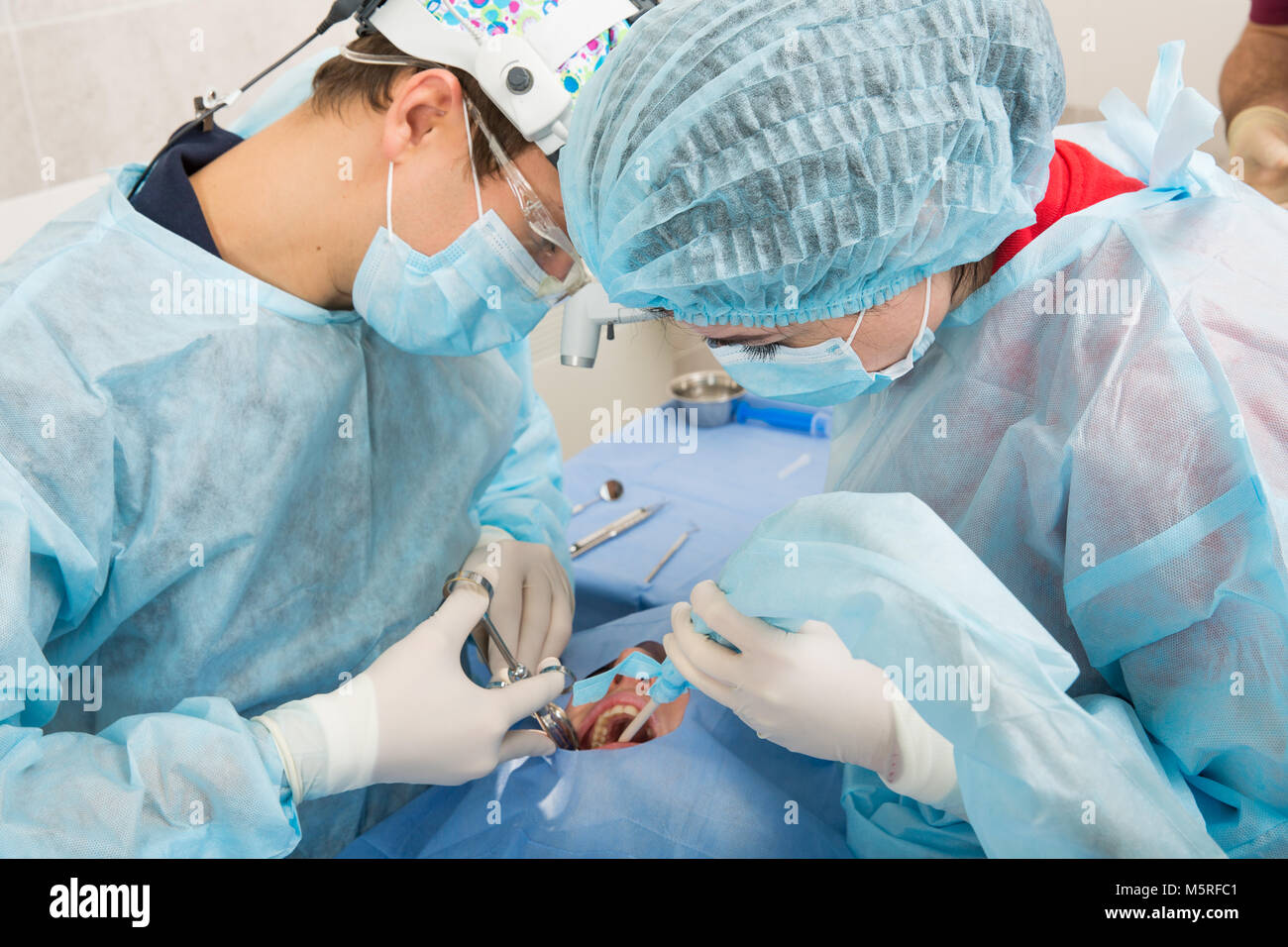 Surgeon Dentist with assistant making professional Using a needle for anesthesia patient at the
