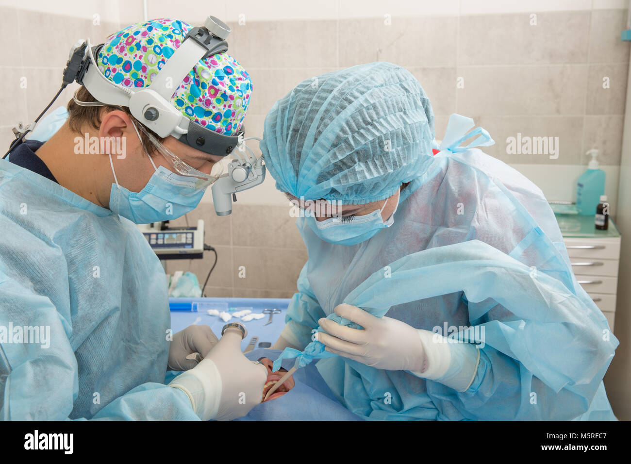 Surgeon Dentist with assistant making professional Using a needle for anesthesia patient at the