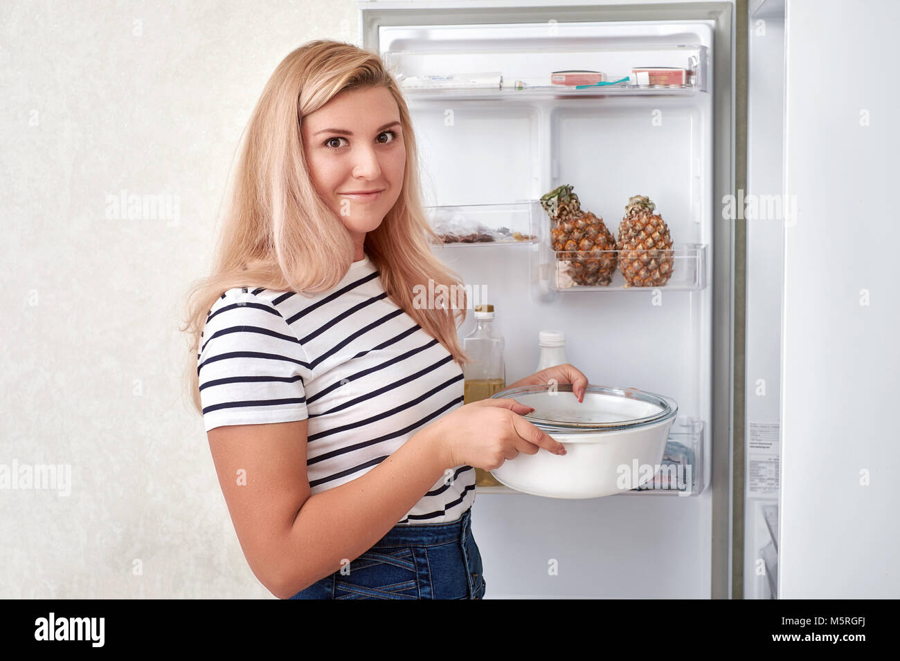 Woman choosing food in refrigerator at home Stock Photo