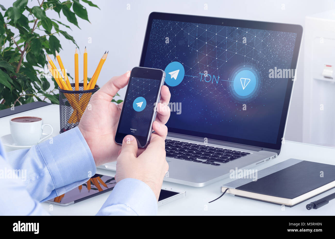 Telegram Open Network TON white paper on the smartphone and laptop screens. Stock Photo