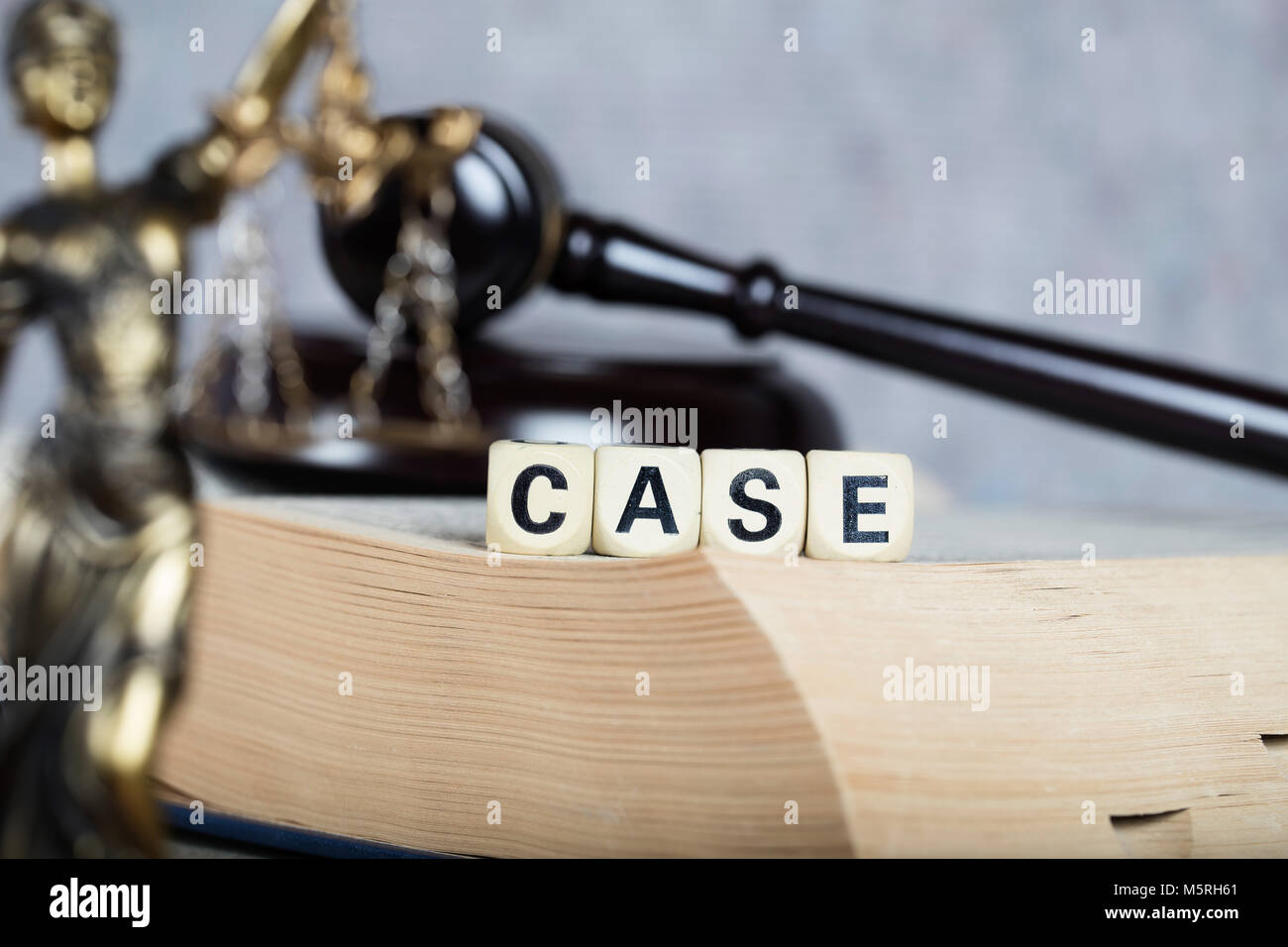 Word CASE composed of wooden letters. Statue of Themis and judge's gavel in the background Stock