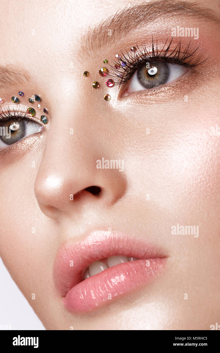 Beautiful girl with creative bright makeup with rhinestones . Beauty face. Stock Photo