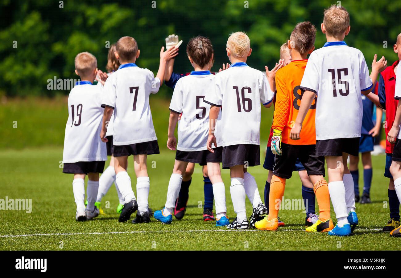 Happy Football Players Giving High Five At Field. Soccer Players High