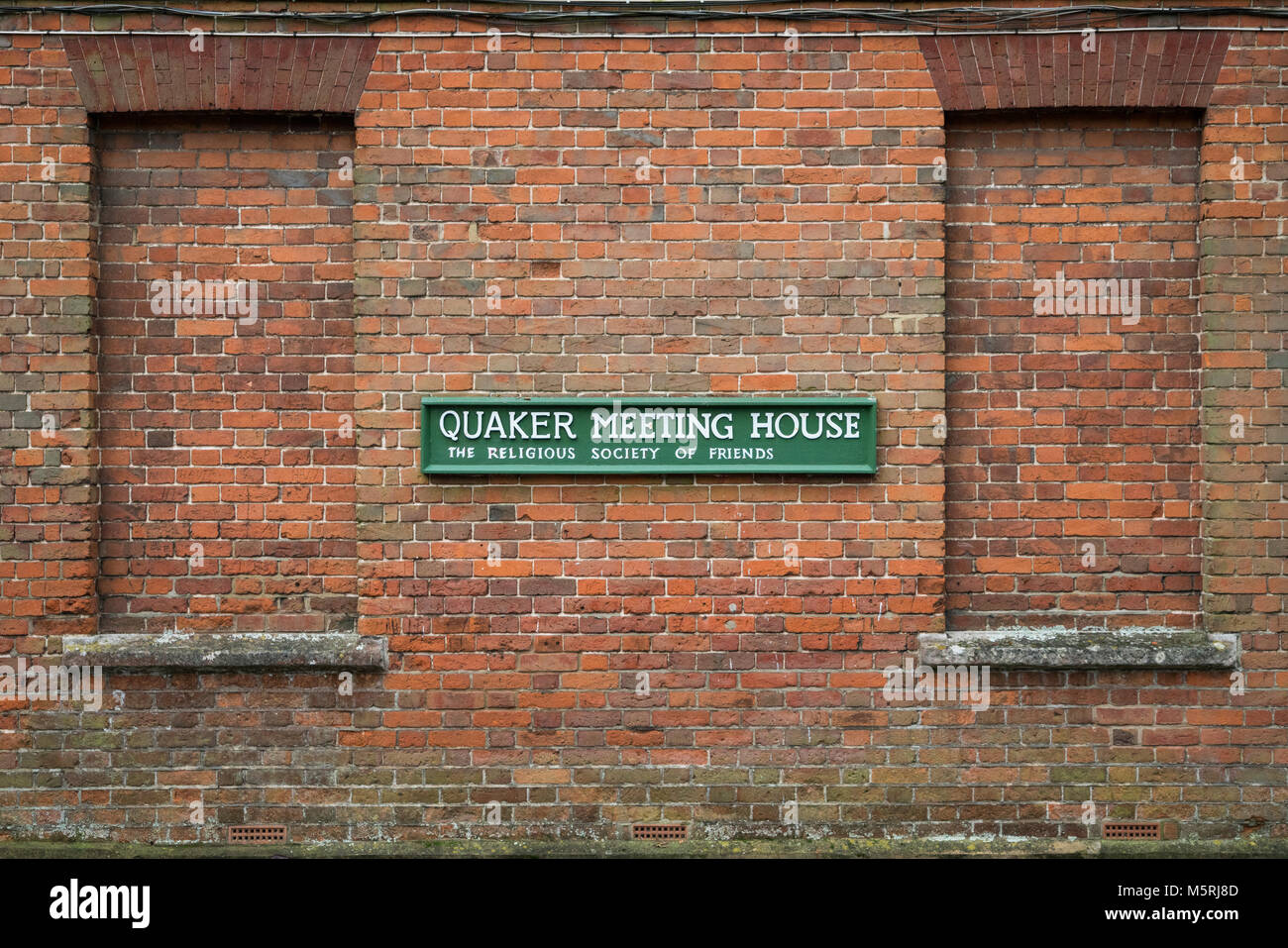 Quaker Meeting House sign on the outside of a red brick building in Winchester, Hampshire, England. Stock Photo