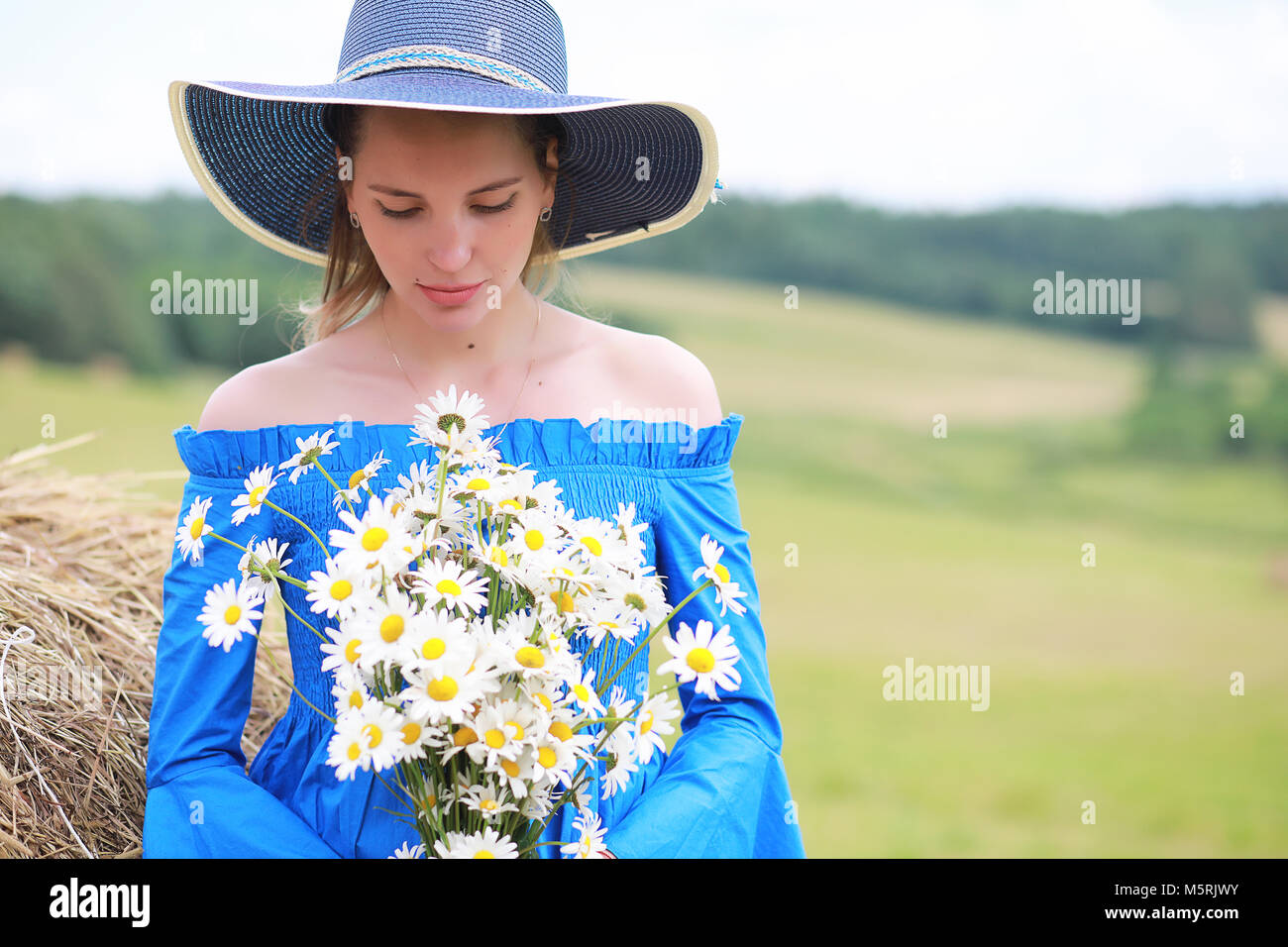 Young cute girl in a hat in a field at sunset Stock Photo - Alamy