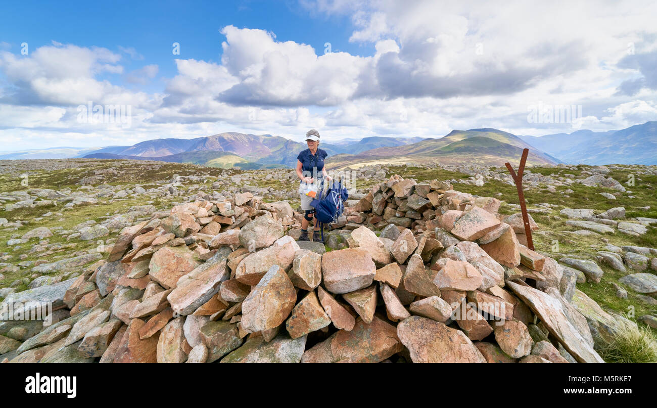LAKE DISTRICT, CUMBRIA, ENGLAND, UK - SEPTEMBER 02, 2017: A female hiker arrives at the summit shelter of Great Borne with views of Grasmoor, Robinson Stock Photo