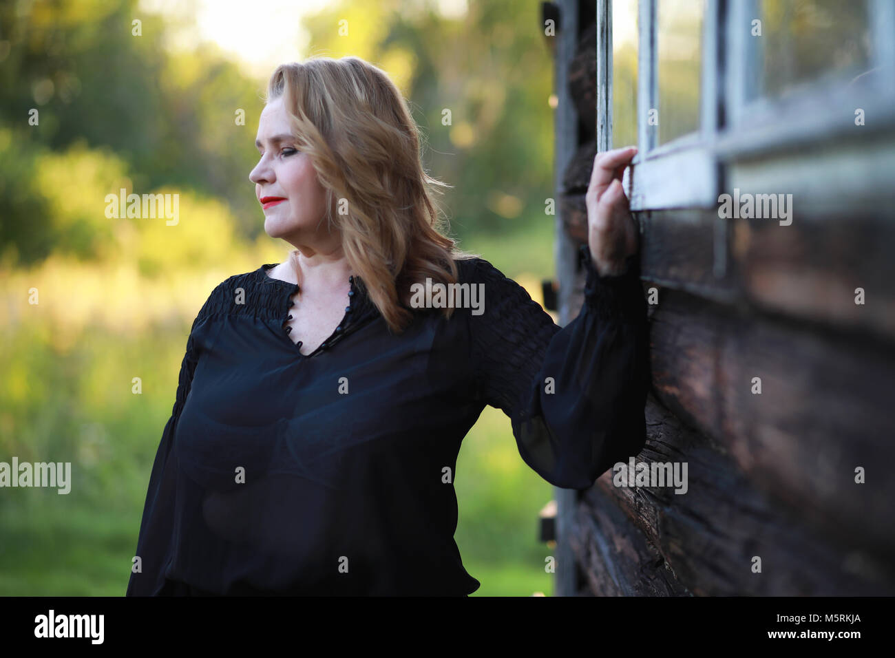 An elderly woman on the porch of a house Stock Photo - Alamy