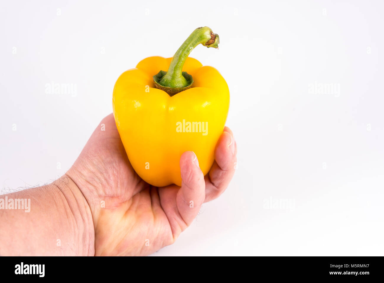 a yellow pepper in hand Stock Photo