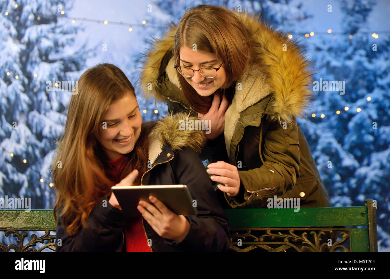 Teen Girls Using Mobile Devices in park Stock Photo