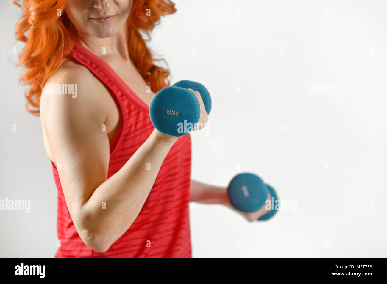 young pretty woman holding weights in studio Stock Photo