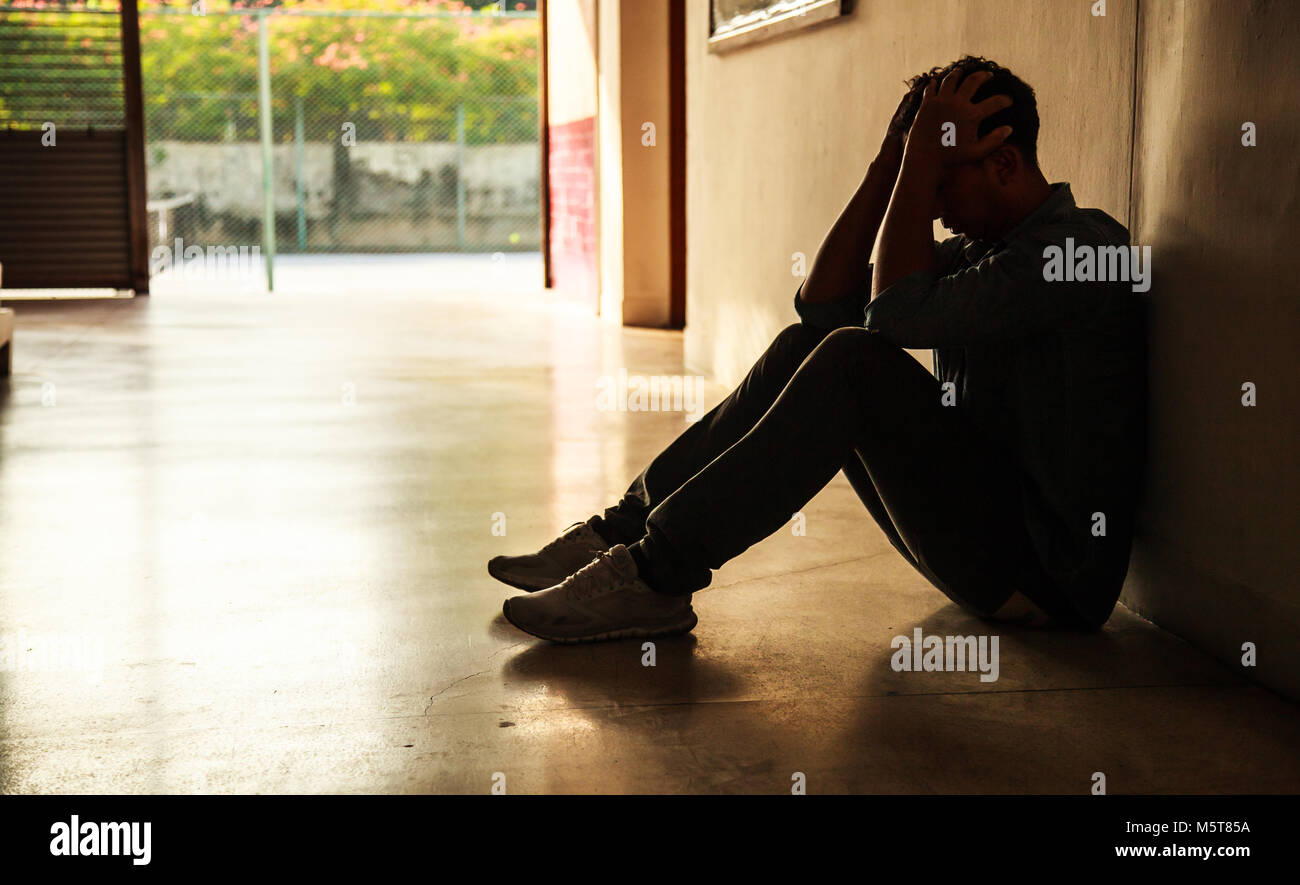 Emotional moment: man sitting holding head in hands, stressed sad young ...