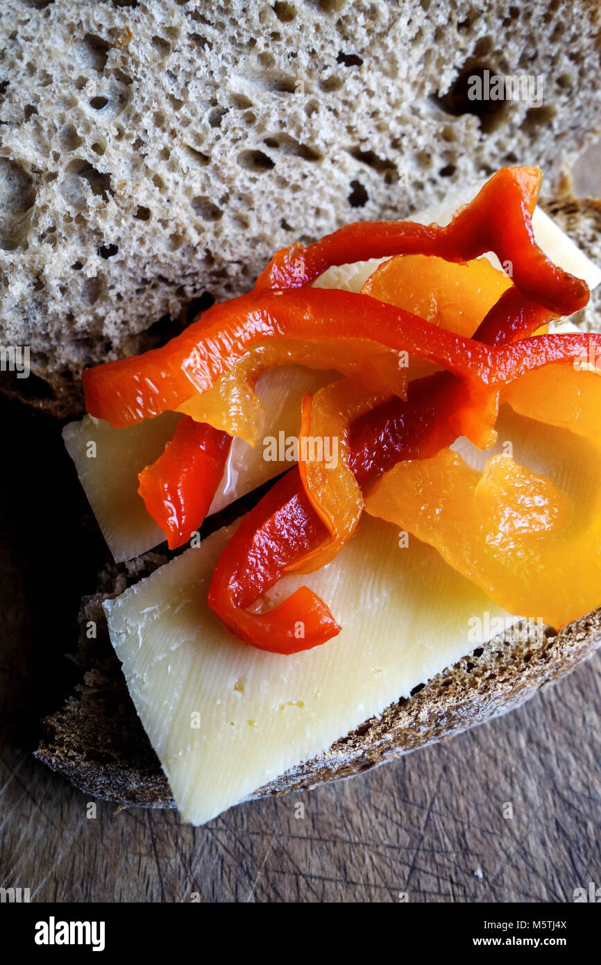 Open Sandwich of Edam Cheese Slices with Red and Yellow Peppers on Brown Wholewheat Bread Stock Photo