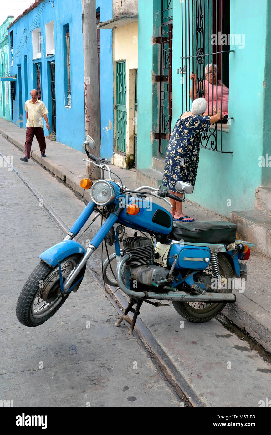 Street scene with motorcycle and old women talking, Camagüey, Cuba Stock Photo