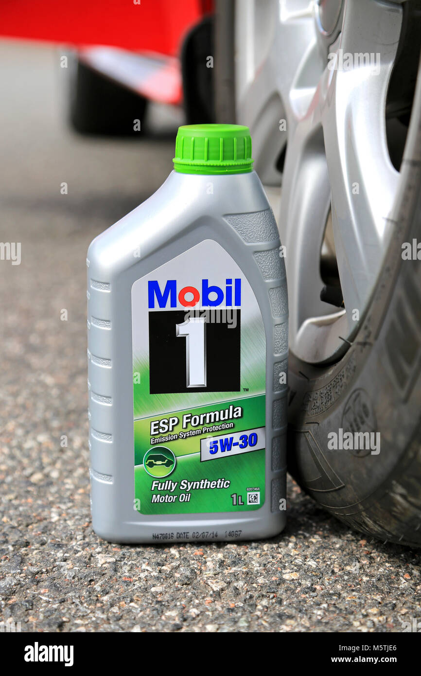 LOIMAA, FINLAND – APRIL 25, 2015: A container of Mobil1 5W-30 fully synthetic Motor oil against car tyre. Multiweight oils such as 5W-30 have polymers Stock Photo