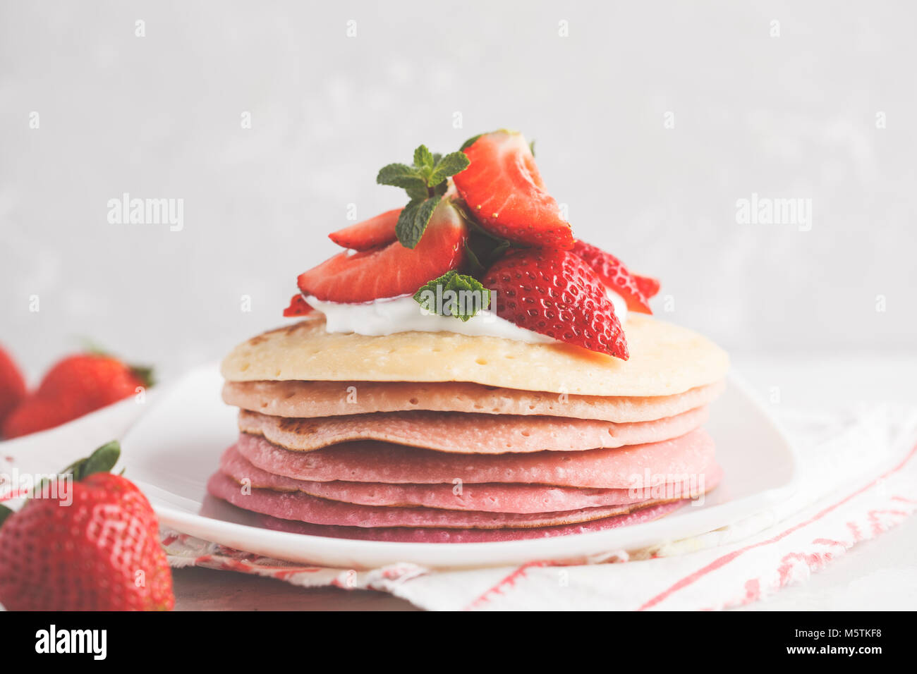 Stack of pink ombre pancakes with strawberry. Breakfast background, copy space. Stock Photo