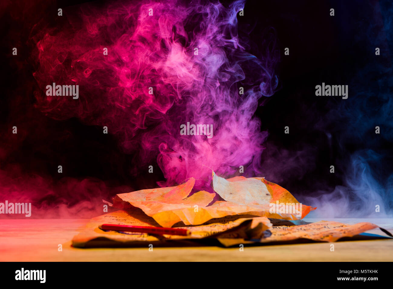 colorful smoke from vintage papers on table Stock Photo