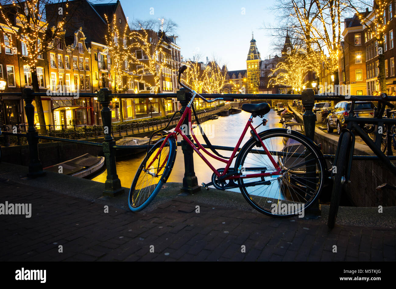 A classic red bicycle at night Amsterdam. Stock Photo