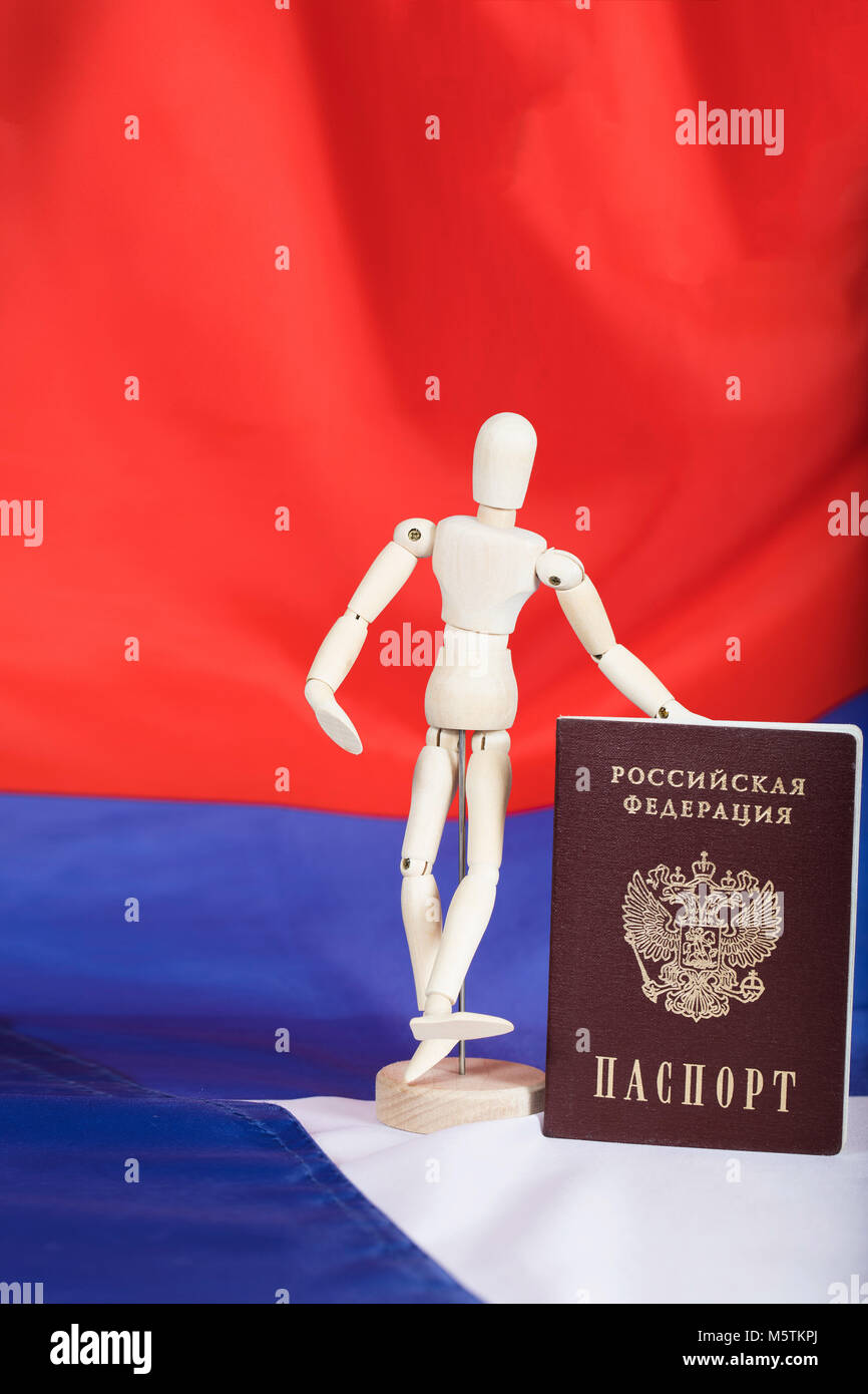 Russian pass and wooden dummy figurine on Russian flag. Closeup Stock