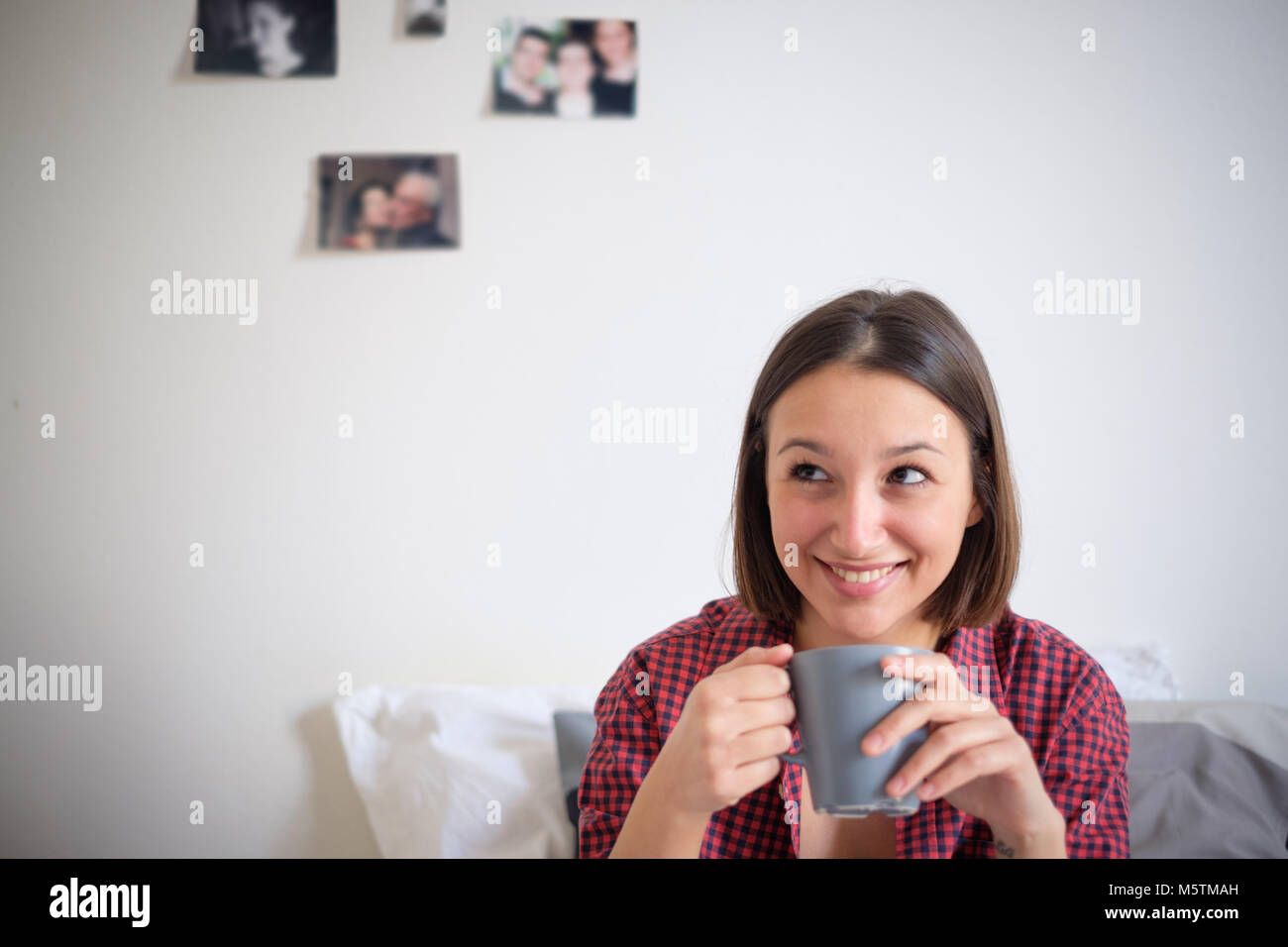 Young girl feeling comfortable and drinking hot drink from a cup Stock Photo