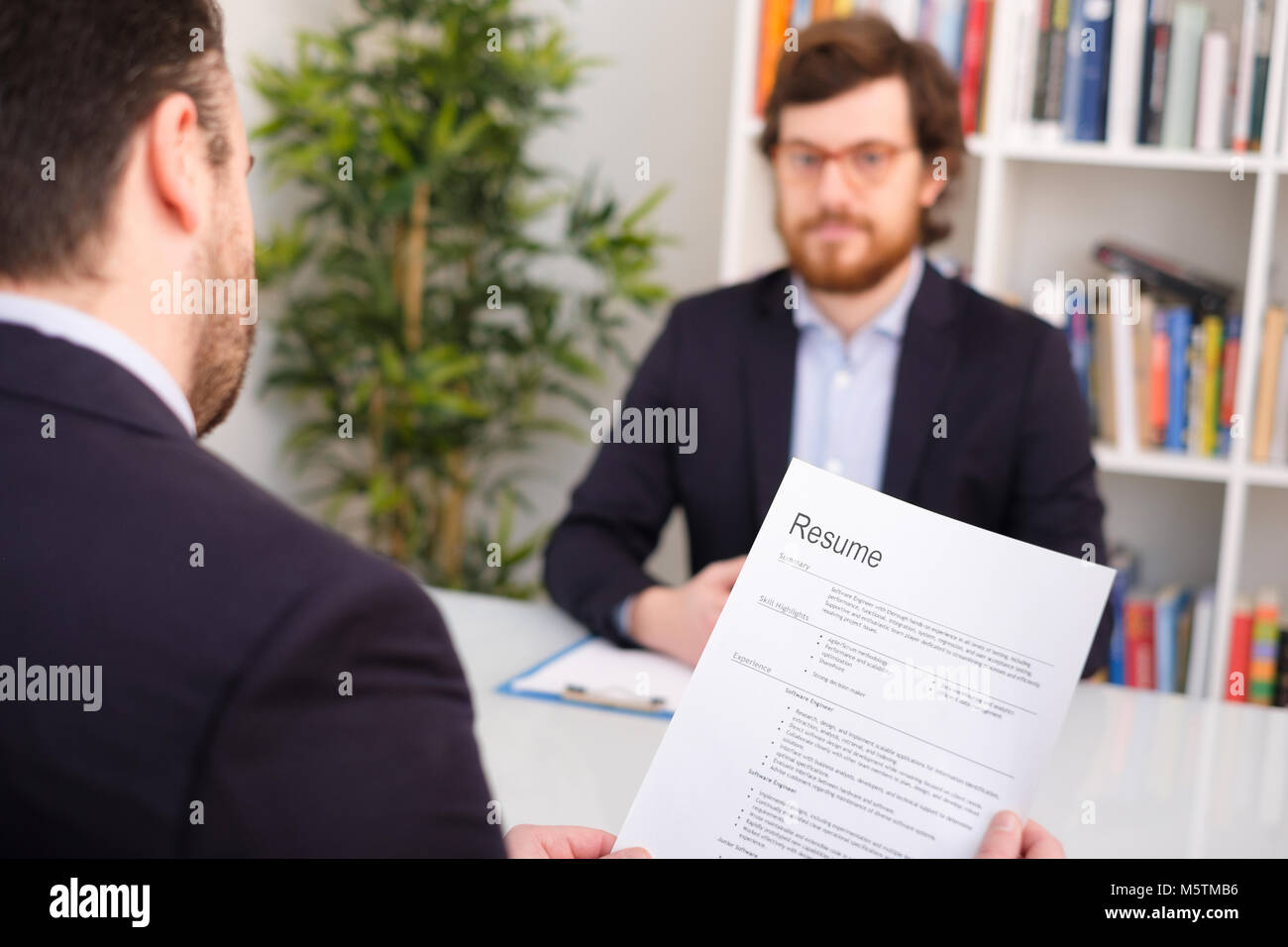 Recruiter reading curriculum during job interview Stock Photo