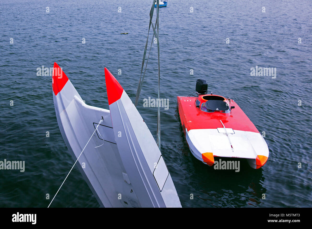 An offshore boat is pulled up by a crane after an accident in the race
