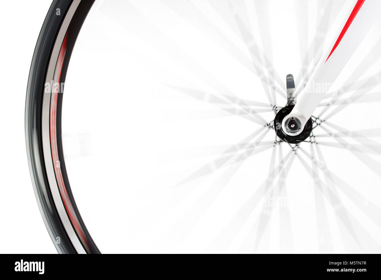The front wheel of the bicycle rotates quickly on a white background