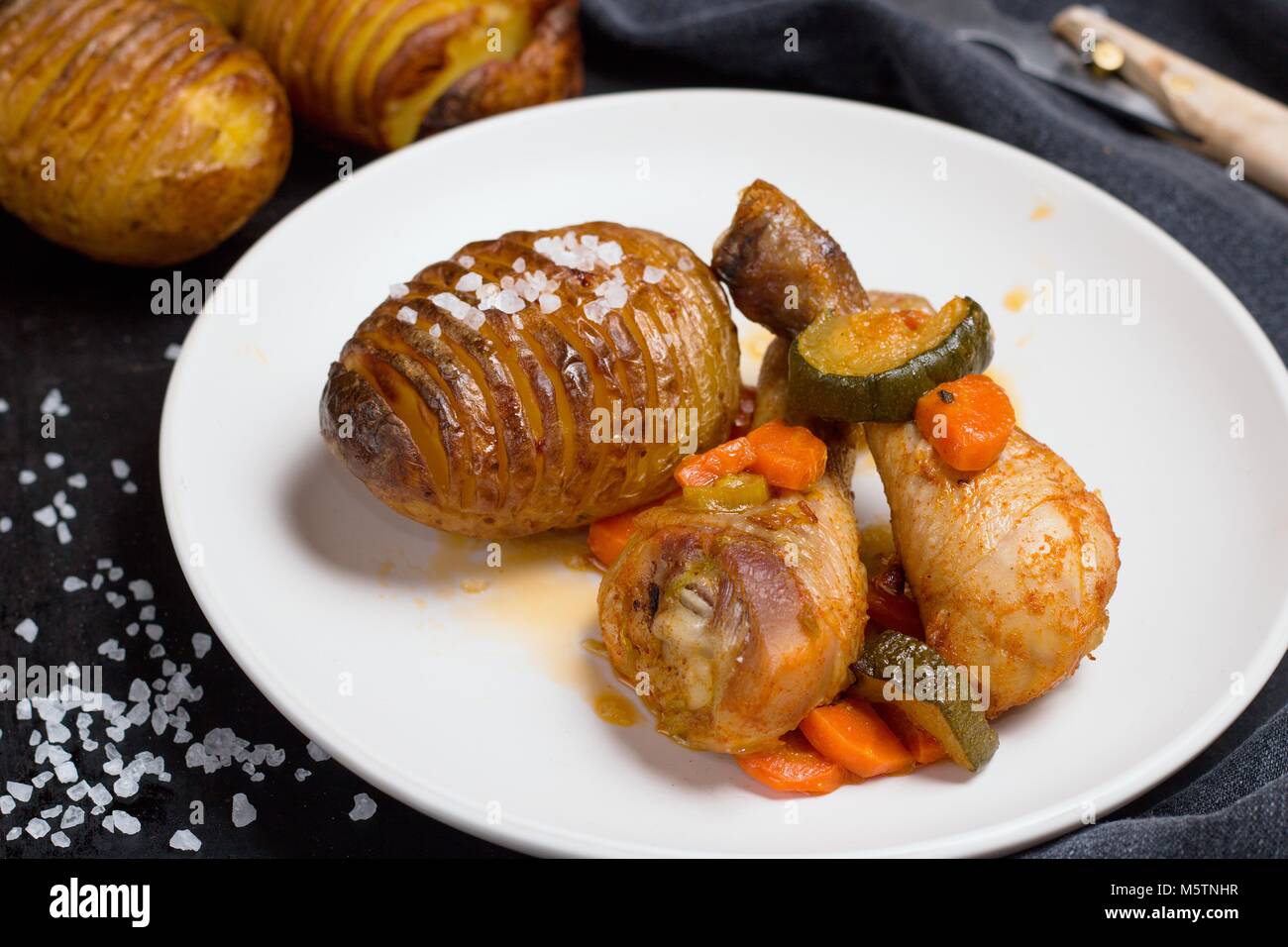Close up shot of hasselback potatoes as side dish to roasted chicken