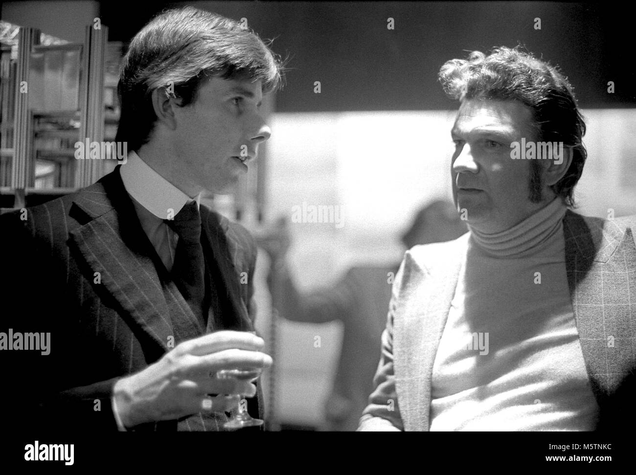 Architectural historian Gavin Stamp columnist for Private Eye magazine as Piloti, in conversation with a man at the RIBA Heinz Gallery in 1975 London UK  KATHY DEWITT Stock Photo