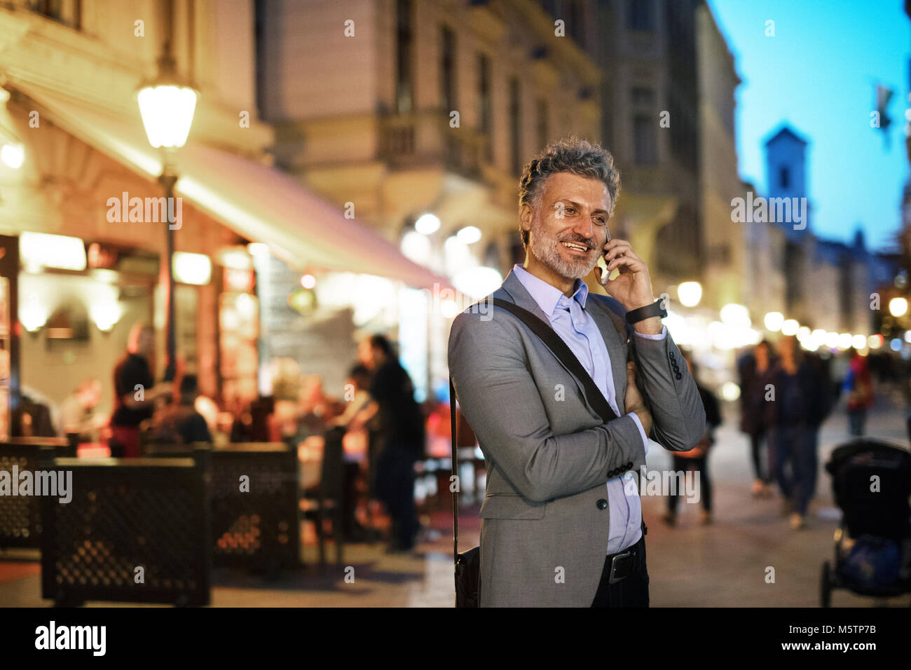 Mature businessman with a smartphone in a city Stock Photo - Alamy