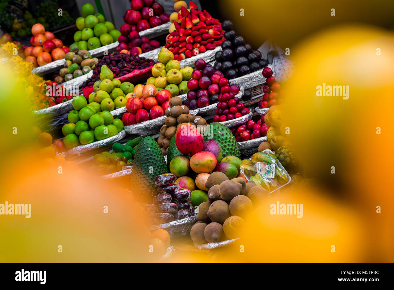 Piles of fruits (apples, mangos, guanabanas, sapotes, plums etc.) are