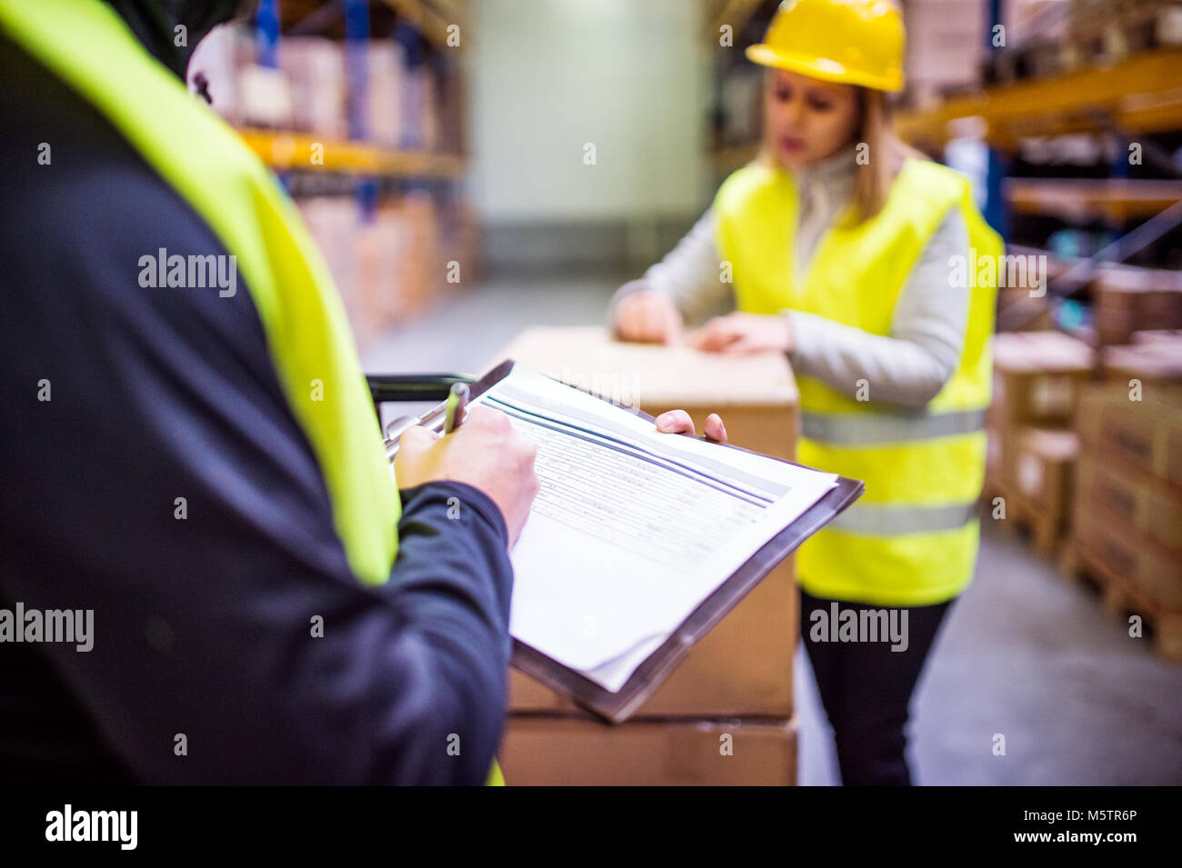 Young warehouse workers working together Stock Photo - Alamy