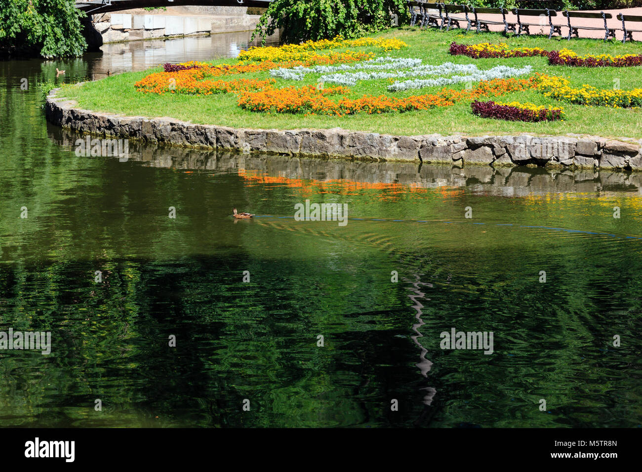 Summer National Dendrology Park of Sofiyivka. Lake and flowerbed on lawn. Uman, Ukraine. Park organized in 19th century. Stock Photo