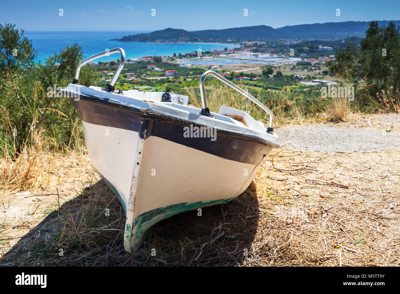 Old small fishing row boat on the coast. Summer landscape of Zakynthos island, Greece Stock Photo