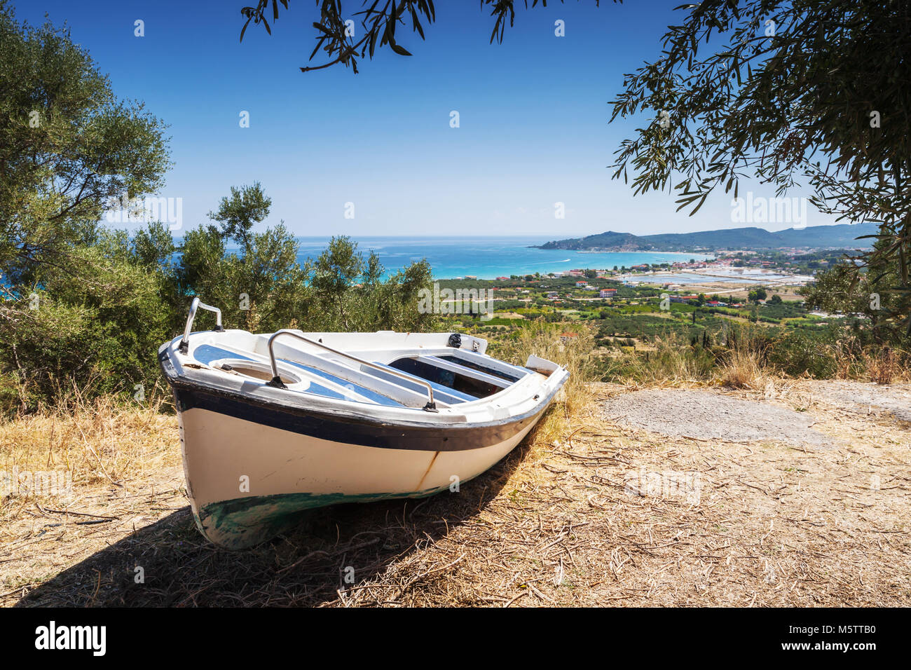 Old white fishing row boat on the coast. Summer landscape of Zakynthos island, Greece Stock Photo