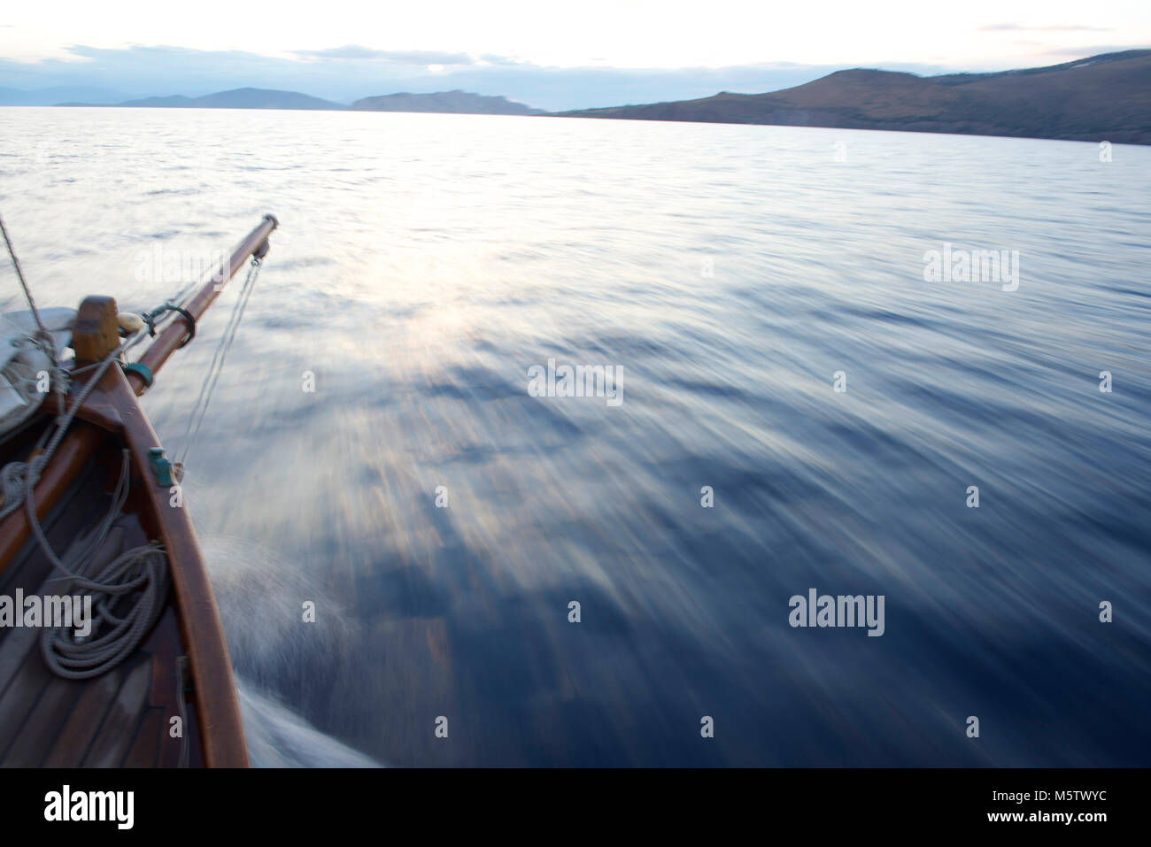 Sailing across the Saronic Gulf towards Aegina, Greece, on a small sailing boat called Chryssopigi at dusk. Stock Photo