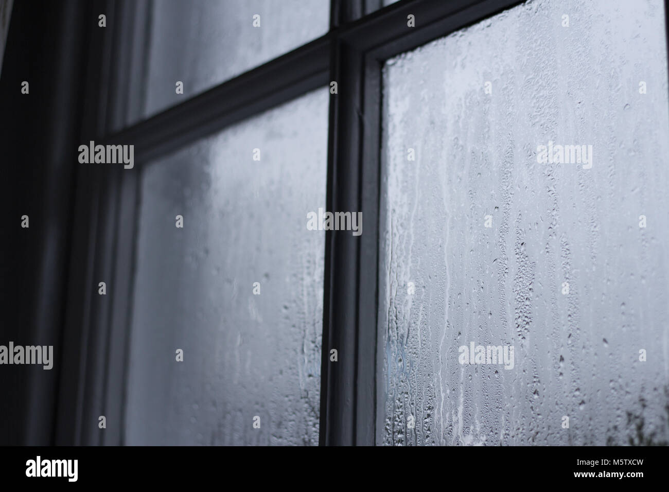 condensation on old wooden frame window in cornish cottage Stock Photo
